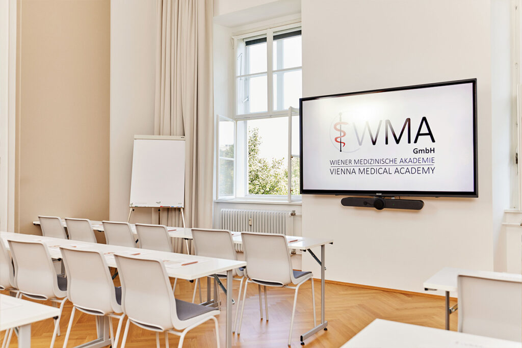 Bildschirm und Whiteboard mit Sesseln in Seminarraum