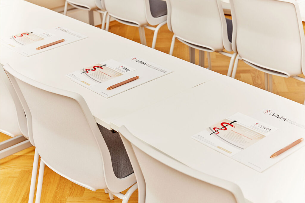 Tische mit Notizblöcken in Seminarraum